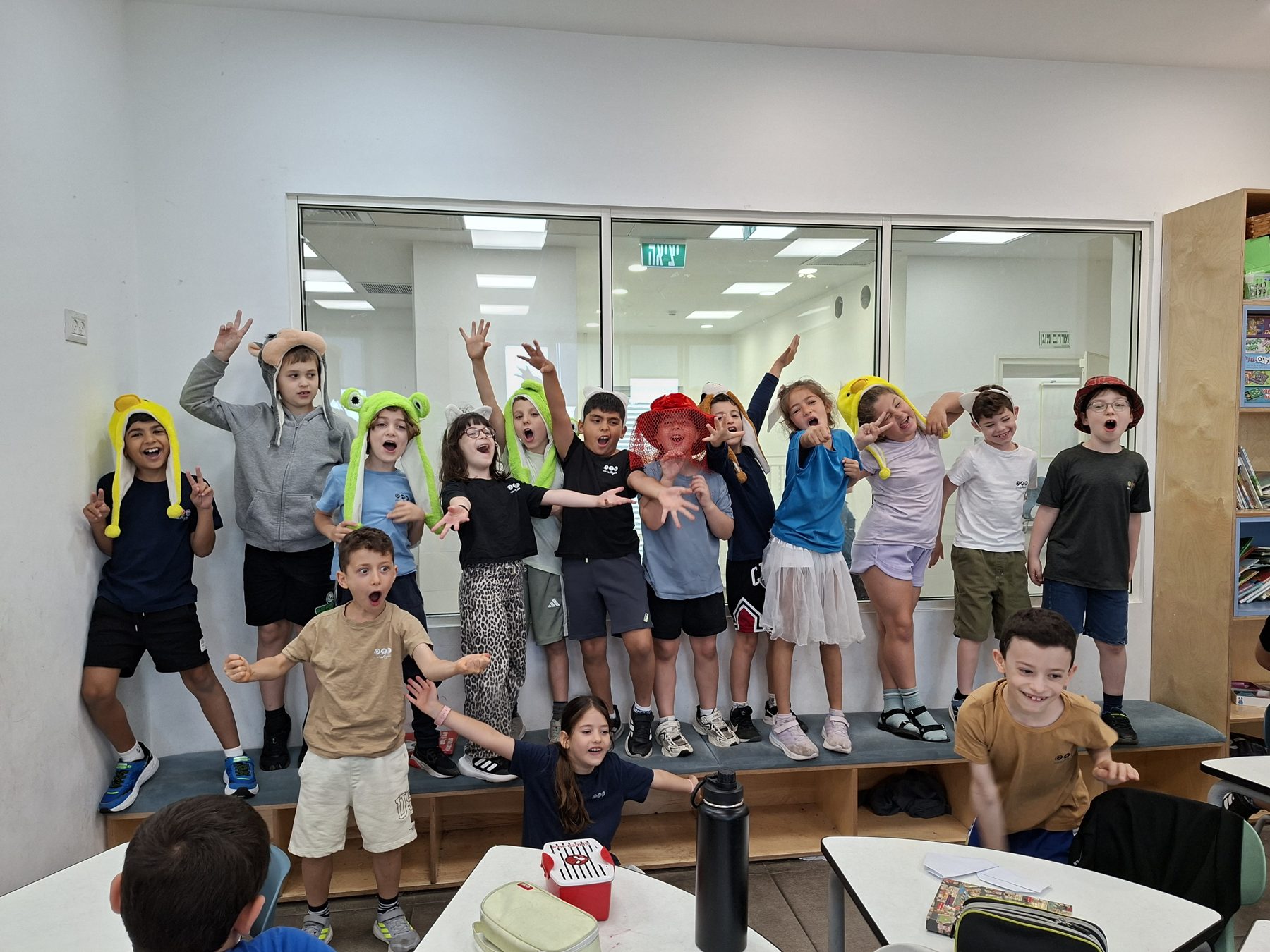 ילדים בתחפושות צבעוניות קופצים בשמחה במעגל תיאטרון